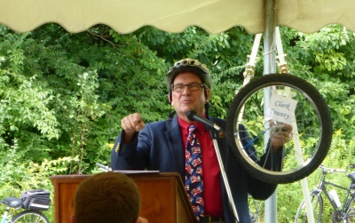 Man in bike helmet holding a bike wheel